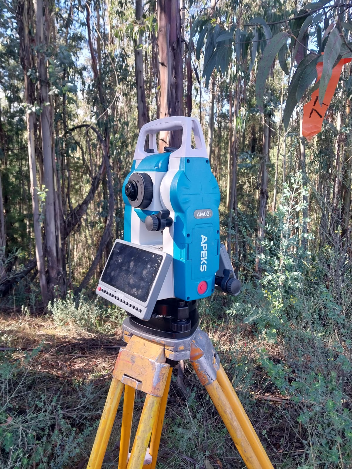 APEKS AM02i total station setup over a DV-26 yellow control point in dense forestry