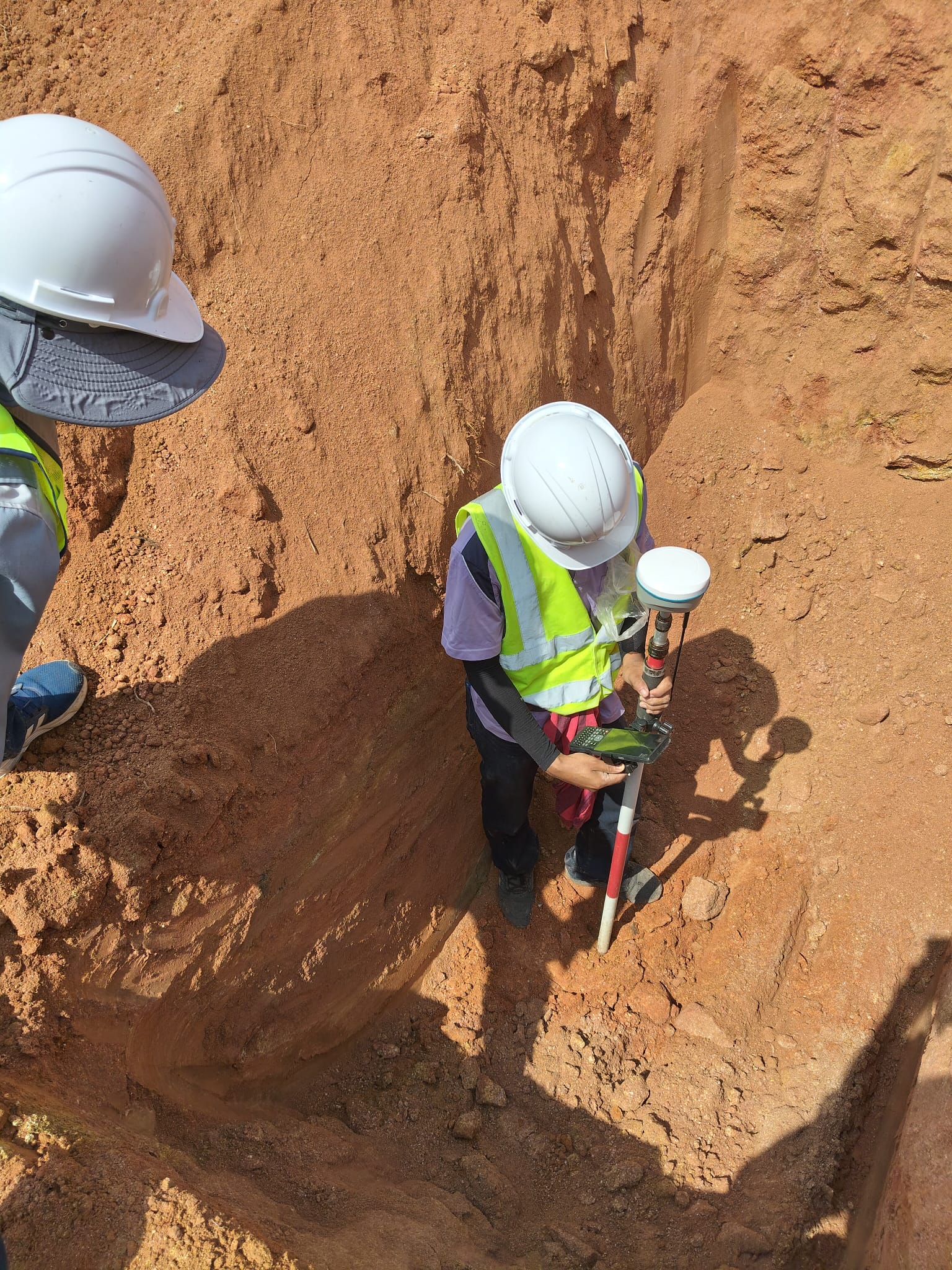 Engineer using APEKS AP10 in a deep red-dirt trench with restricted sky view