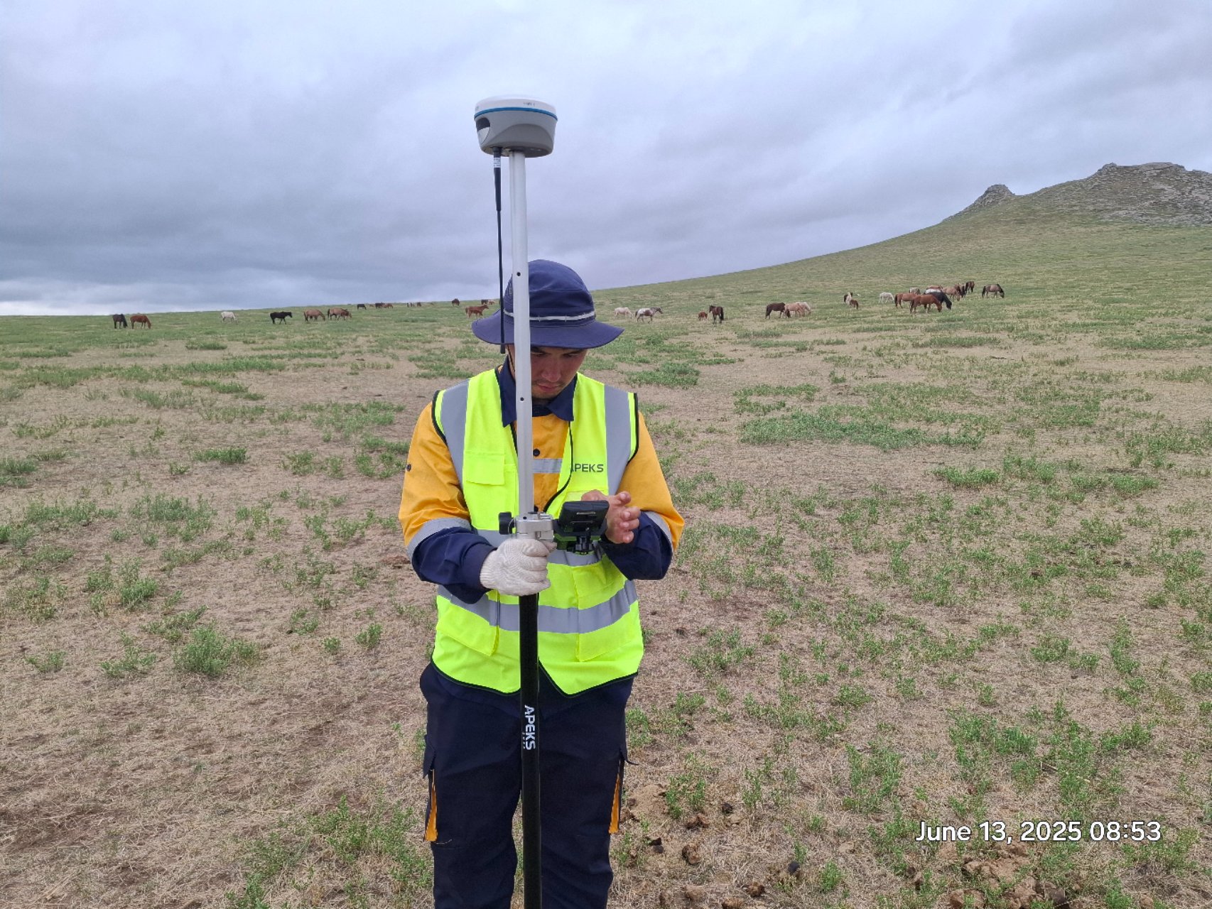 Close-up of a surveyor utilizing an Android-based data collector with APEKS RTK GNSS system in Mongolia