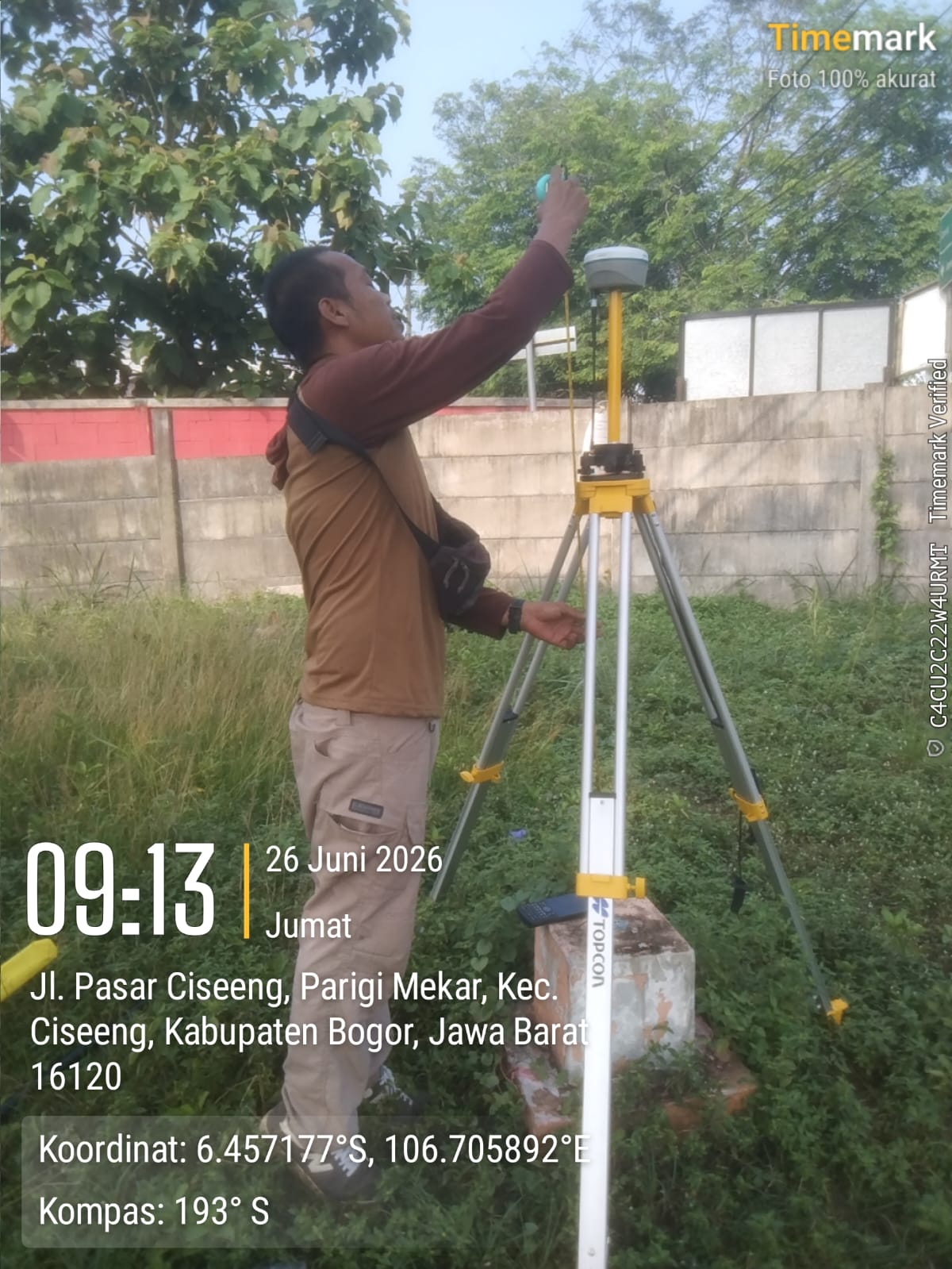 Close-up of a field surveyor measuring the antenna height of a GNSS receiver over an established reference monument in Indonesia