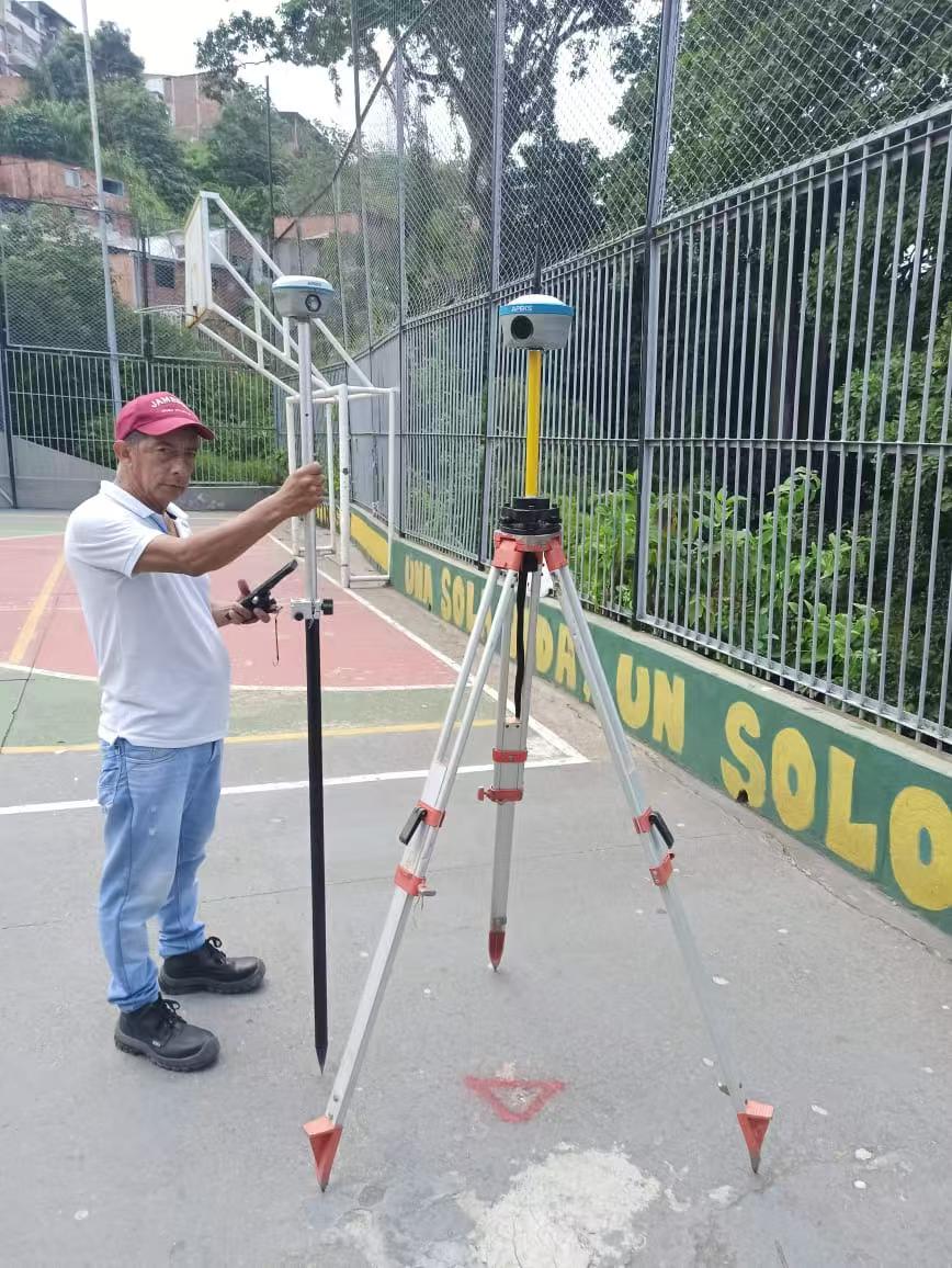 APEKS RTK GNSS base and rover used by a surveyor on a sports court project in Colombia